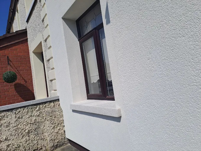 Brick slip facade detail beside smooth render and granite-effect sill